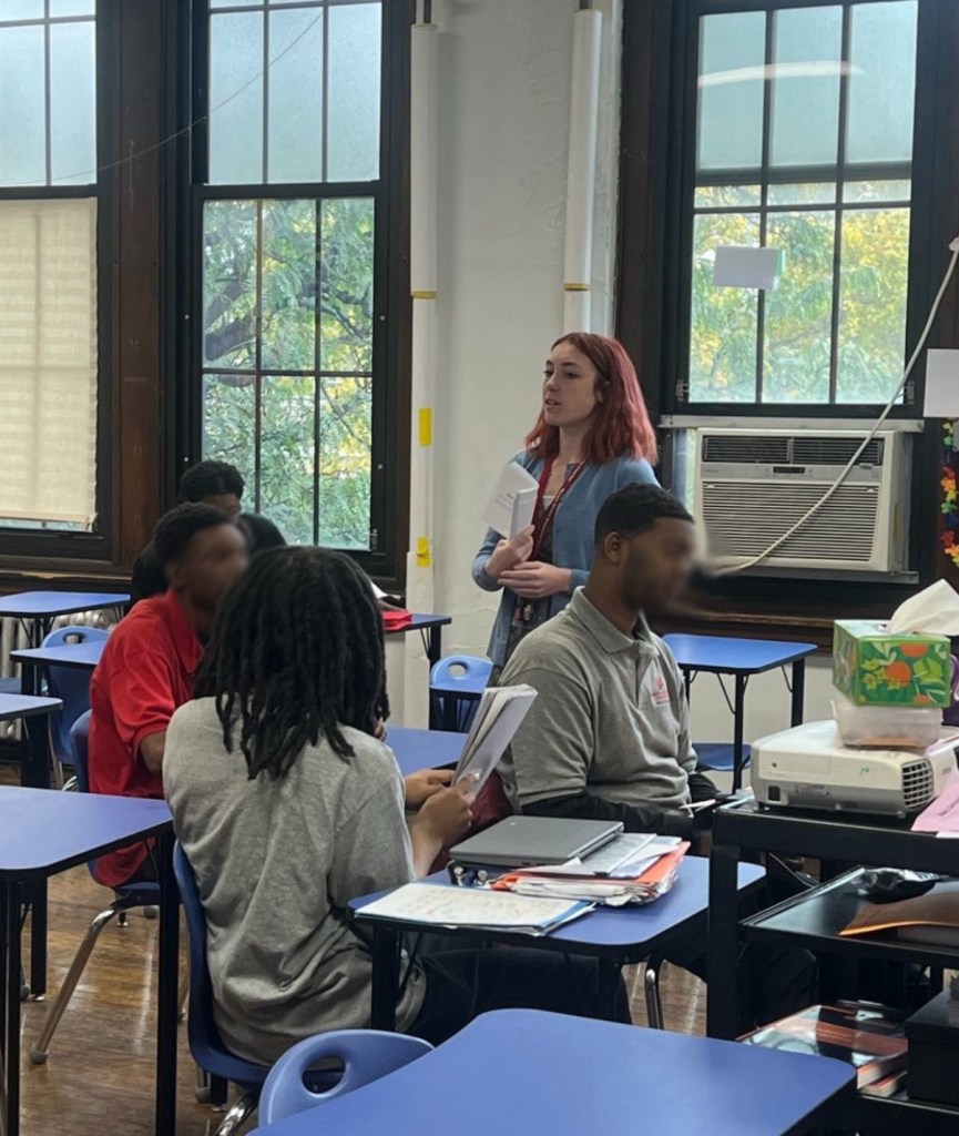 English tutor Ruby Kaufmann speaking to teenage students in a classroom
