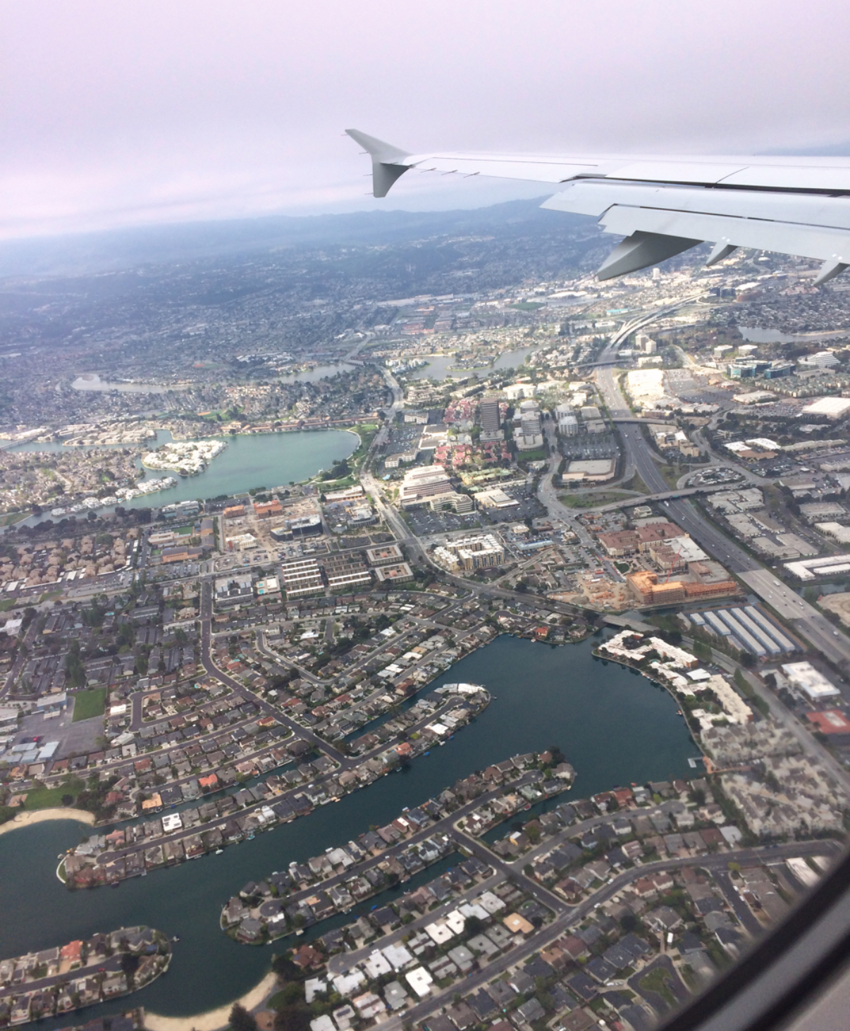 View from an airplane window showing a city from above
